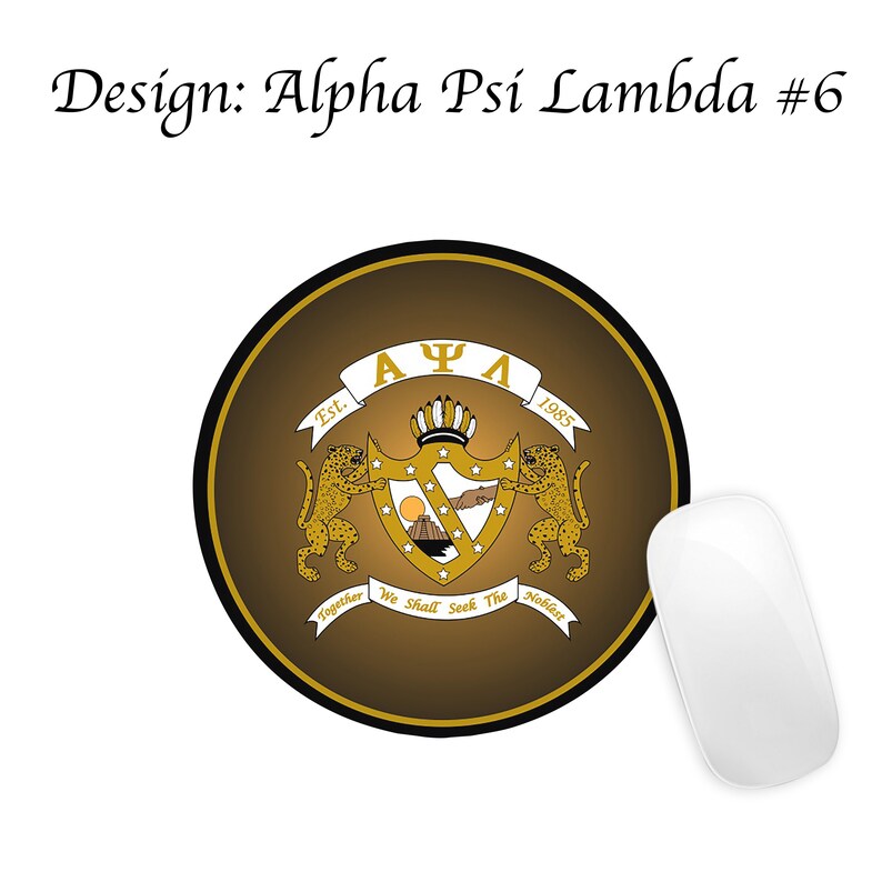 May include: A round brown mouse mat with a gold crest featuring the letters "A&Psi;&Lambda;" and the text "Est. 1985" and "Together We Shall Seek The Noblest".