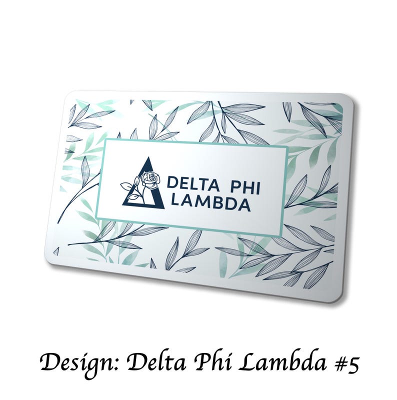May include: A rectangular card with a white background, featuring a floral pattern of green leaves and a central rectangle. The rectangle contains the text "DELTA PHI LAMBDA" and a triangle logo with a rose. The text "Design: Delta Phi Lambda #5" is at the bottom.