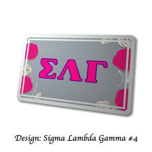 以下が含まれることがあります： 明るいピンク色と紫色の縁取りのギリシャ文字&Sigma;&Lambda;&Gamma;が特徴の長方形の灰色の金属製サイン。ピンクのバラとタン色の花のアクセントで装飾されています。「Design: Sigma Lambda Gamma #4」の文字が下部にあります。