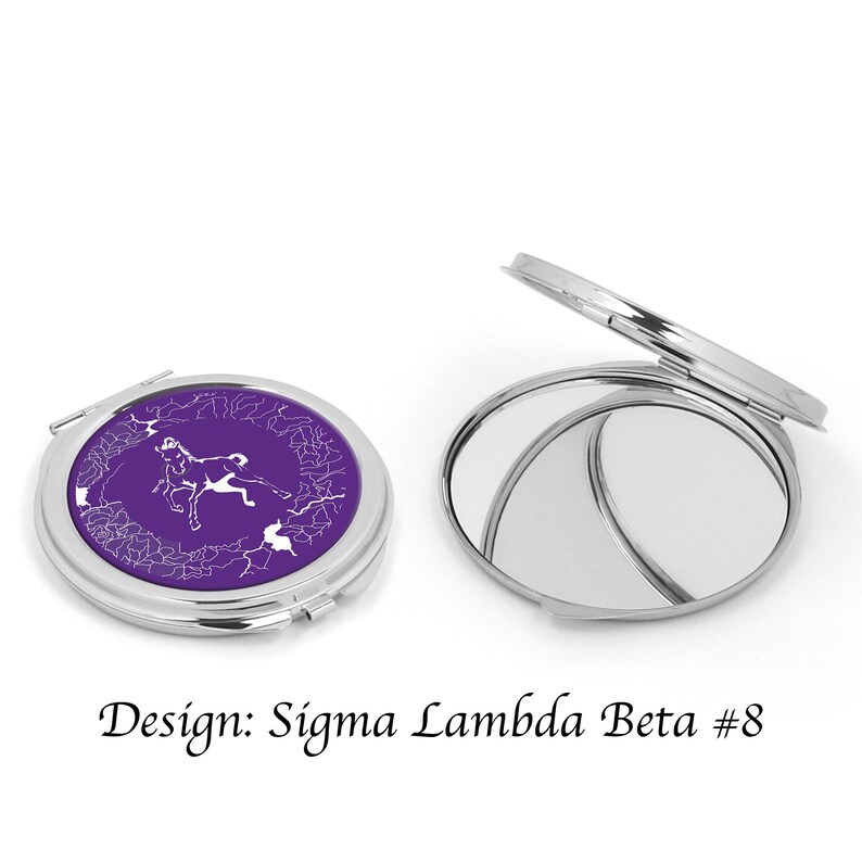 Pu&ograve; includere: Uno specchio compatto argentato con sfondo viola e un design bianco di un cavallo. Il design &egrave; etichettato "Sigma Lambda Beta #8".