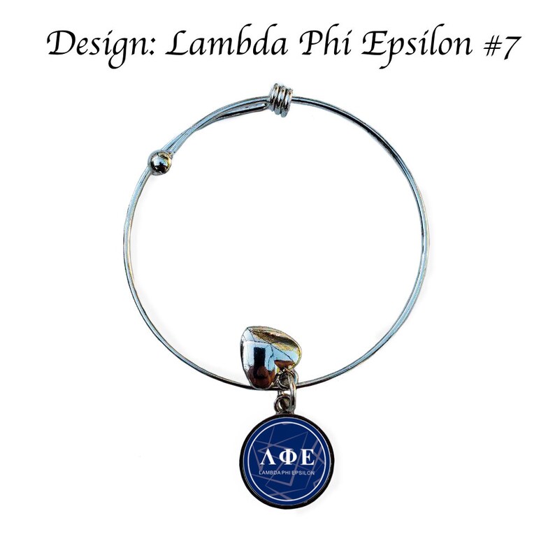 May include: A silver expandable bracelet with a charm featuring a blue circle with the letters "&Lambda;&Phi;&Epsilon;" and the text "Lambda Phi Epsilon" in white.