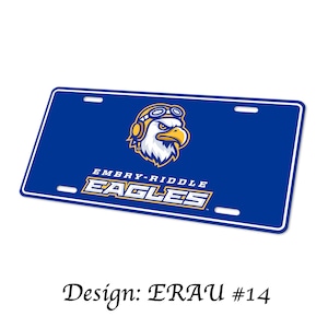 May include: A rectangular blue license plate featuring a white border and four mounting slots. The center displays a graphic of an eagle wearing aviator goggles and headphones, with the text EMBRY-RIDDLE EAGLES printed below in white and gold.