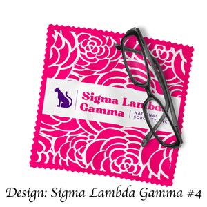 Könnte beinhalten: Ein rosa Mikrofaser-Reinigungstuch mit einem weißen Rosenmuster und dem Text "Sigma Lambda Gamma National Sorority, Inc." Eine schwarze Brille liegt auf dem Tuch.