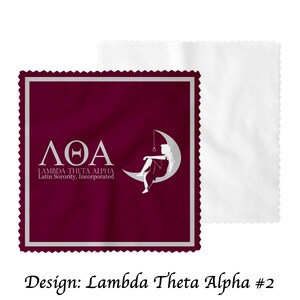 May include: A burgundy microfiber cleaning cloth with a white border and a silver Greek letter design. The design features the letters &Lambda;&Theta;&Alpha;, which stand for Lambda Theta Alpha, a Latin sorority. The text "Latin Sorority, Incorporated" is also included in the design.