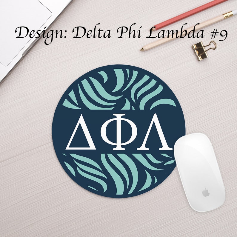 Może przedstawiać: Okrągła podkładka pod mysz z niebieskim tłem i wzorem turkusowych zwoj&oacute;w. Litery "&Delta;&Phi;&Lambda;" są białe i znajdują się w środku podkładki.