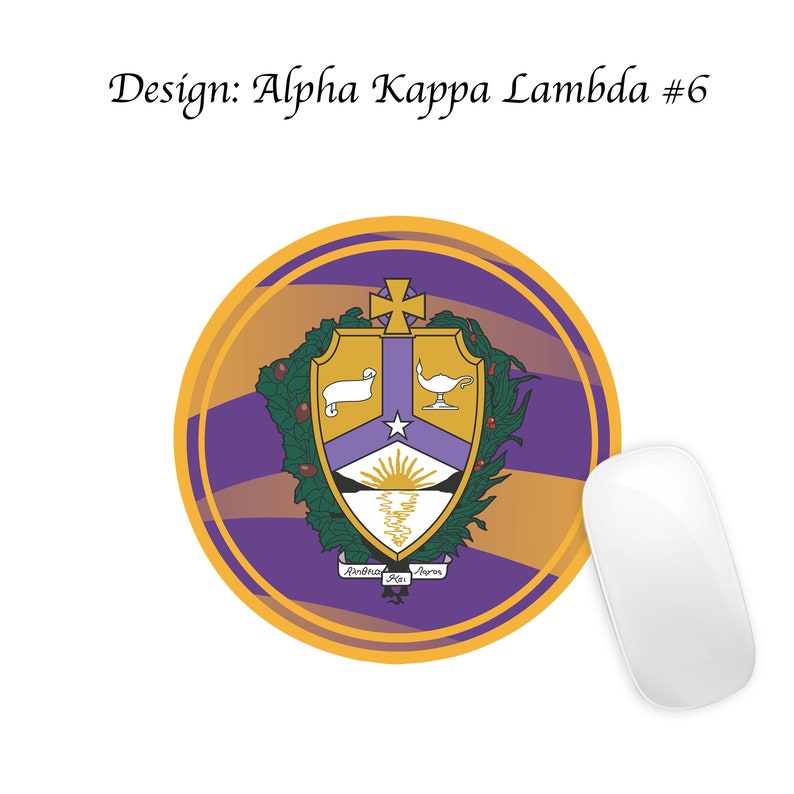 Pode incluir: Um mousepad redondo roxo e dourado com um bras&atilde;o que apresenta um cordeiro branco, uma l&acirc;mpada dourada, uma estrela e um nascer do sol. O bras&atilde;o &eacute; cercado por folhas verdes e o texto "Alpha Kappa Lambda" est&aacute; escrito em uma faixa abaixo do bras&atilde;o.