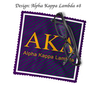K&ouml;nnte beinhalten: Ein quadratisches St&uuml;ck Stoff mit violettem und gr&uuml;nem Muster, auf dem die Buchstaben "AKA" in goldener Schrift und der Text "Alpha Kappa Lambda" in wei&szlig;er Schrift stehen. Ein Paar schwarze Brillen liegt auf dem Stoffquadrat.