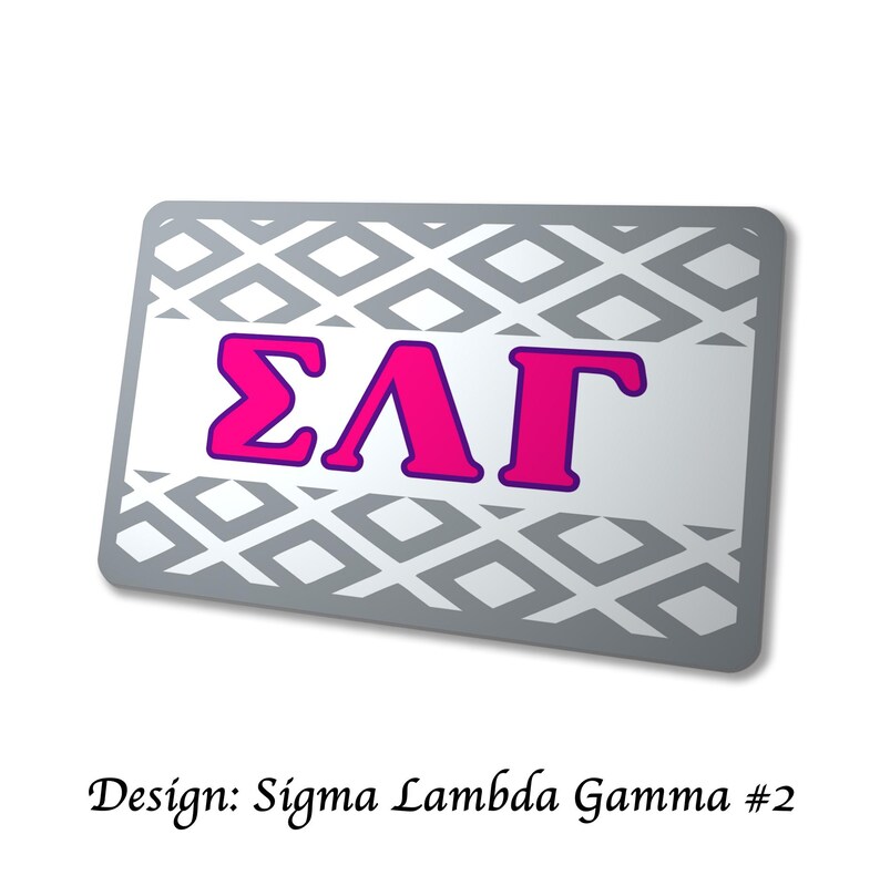 以下が含まれることがあります： グレーのひし形模様と、紫色の縁取りのある鮮やかなピンク色のギリシャ文字&Sigma;&Lambda;&Gamma;が特徴の、長方形の銀色のアイテム。「Design: Sigma Lambda Gamma #2」の文字が下部にあります。