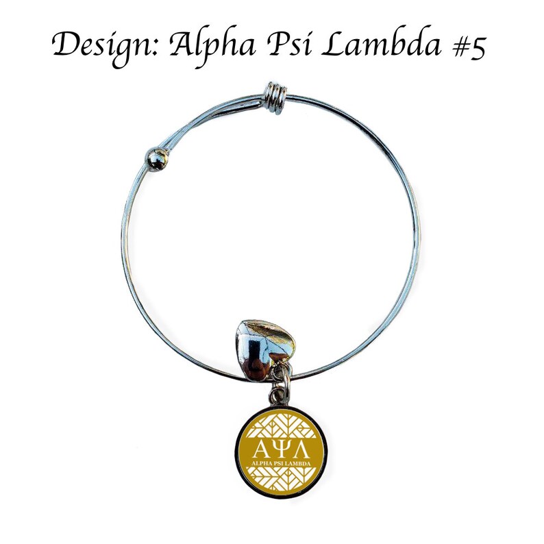May include: A silver expandable bracelet with a charm featuring a gold circle with a white Greek letter design and the text "Alpha Psi Lambda".