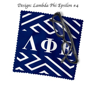 May include: A navy blue cleaning cloth with a white geometric pattern and the Greek letters Lambda, Phi, and Epsilon. Black eyeglasses rest on the cloth. The text "Design: Lambda Phi Epsilon #4" is at the top.