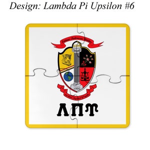 Op de afbeelding: Een wit puzzelstuk met een gele rand. Het puzzelstuk heeft een wapenschild met een rood, zwart en geel schild, een wereldbol, een weegschaal en een kolom. Het wapenschild wordt omringd door een rood lint met de tekst "Latinas Poderosas Unidas" en "Con Amor, Dignidad y Orgullo". De tekst "ΛΠΥ" staat onder het wapenschild.