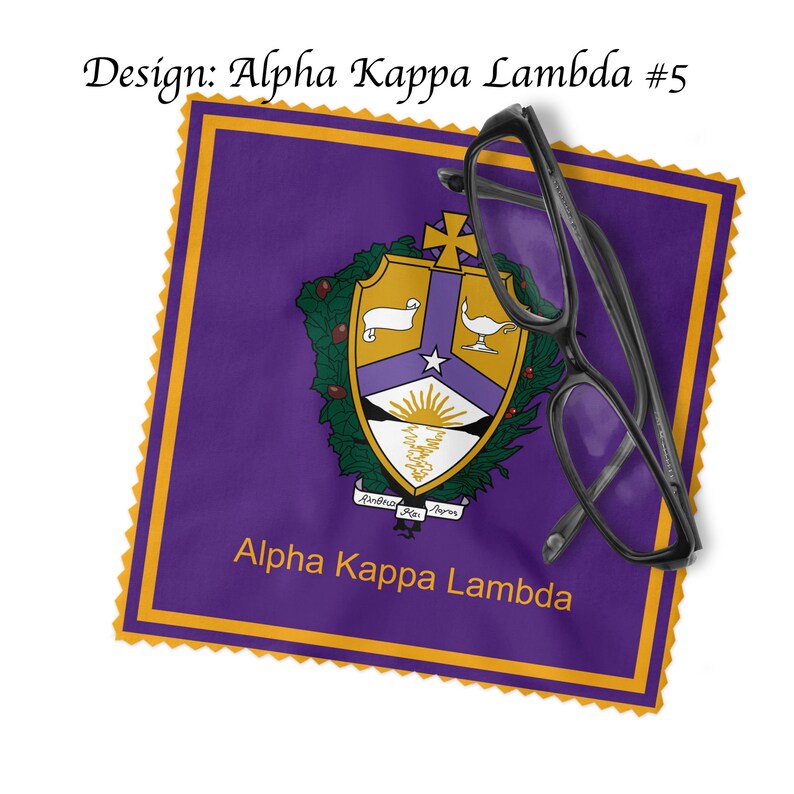 K&ouml;nnte beinhalten: Lilafarbener und goldener Stoffquadrat mit einem Wappen, das einen wei&szlig;en Stern, einen Sonnenaufgang, ein Lamm und eine Lampe zeigt. Der Text "Alpha Kappa Lambda" ist unter dem Wappen gedruckt.