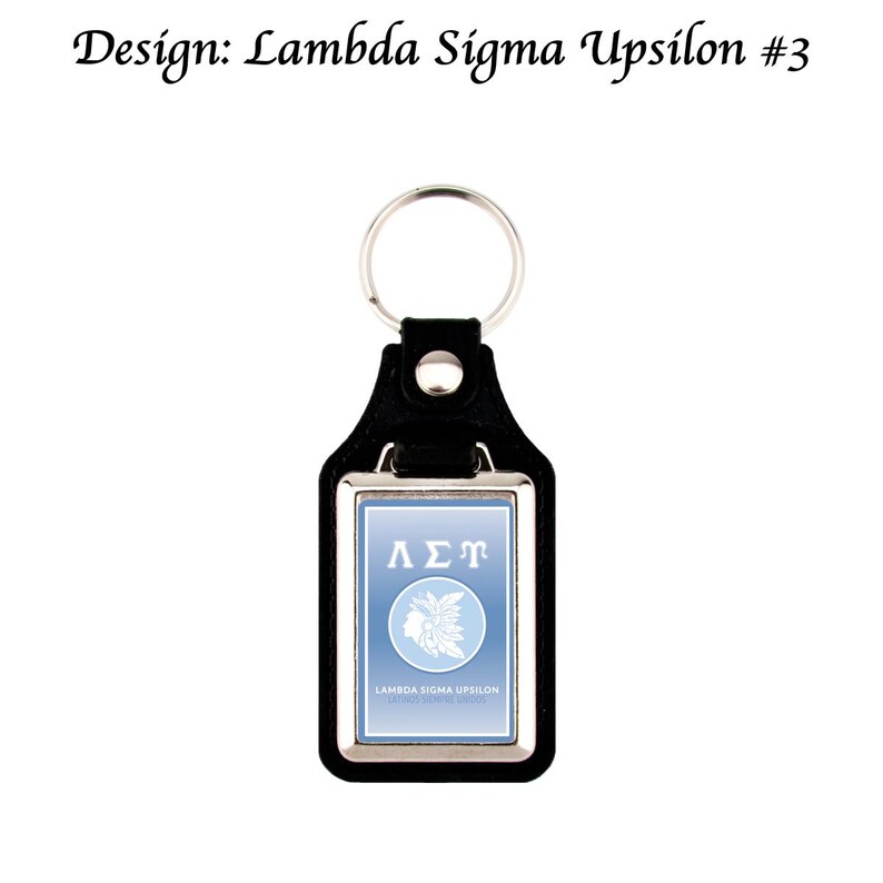 May include: Black leather keychain with a silver-coloured metal frame. The keychain features a light blue rectangular insert with the Greek letters &Lambda;&Sigma;&Tau; and a Native American profile. The text "Lambda Sigma Upsilon" is also visible.