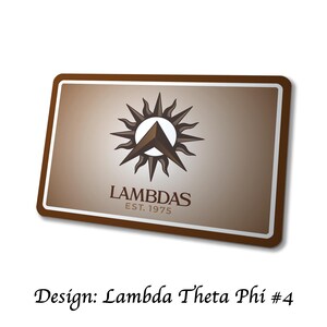 Puede incluir: Un letrero rectangular con borde marr&oacute;n y fondo degradado. El letrero presenta un logotipo con un dise&ntilde;o de sol alrededor de un tri&aacute;ngulo, la palabra "LAMBDAS" y "EST. 1975". El texto "Design: Lambda Theta Phi #4" est&aacute; en la parte inferior.