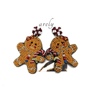 May include: A pair of gingerbread man earrings made of colorful beads. The earrings are a festive holiday accessory.