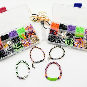 May include: Two clear plastic containers filled with various Halloween-themed beads, including black, white, orange, green, and purple beads. Four bracelets made with the beads are shown below the containers.