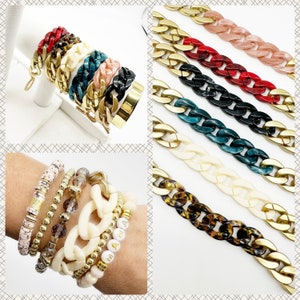 Peut inclure: Un ensemble de bracelets chaîne épais et colorés avec différents motifs et couleurs, notamment rouge, noir, blanc, vert et marron. Les bracelets sont en plastique et ont une finition brillante.