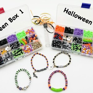 May include: Two clear plastic containers filled with colorful beads and charms labeled "Halloween Box 1" and "Halloween Box 2". Four bracelets made with beads and charms are displayed below the containers.
