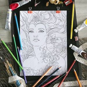 May include: A black and white line art coloring page featuring a woman with long flowing hair, a crown, and a raven perched on her shoulder. The woman is surrounded by crystals and vines.