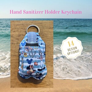 May include: A fabric hand sanitizer holder keychain featuring a blue and white striped pattern with cartoon characters, anchors, and sun icons. The holder includes a clear plastic bottle and a metal ring. Text reads Hand Sanitizer Holder Keychain.