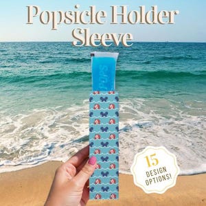 May include: A blue popsicle holder sleeve with a pattern of red beach balls and blue Mickey Mouse silhouettes. The text "Popsicle Holder Sleeve" is at the top. The holder contains a blue popsicle. The image also includes the text "15 DESIGN OPTIONS!"