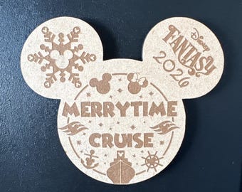 May include: A light brown wooden cutout shaped like a Mickey Mouse head. The left ear features a snowflake design. The right ear displays the text Disney FANTASY 2026. The center circle reads MERRYTIME CRUISE with icons of a ship, anchor, and wheel.