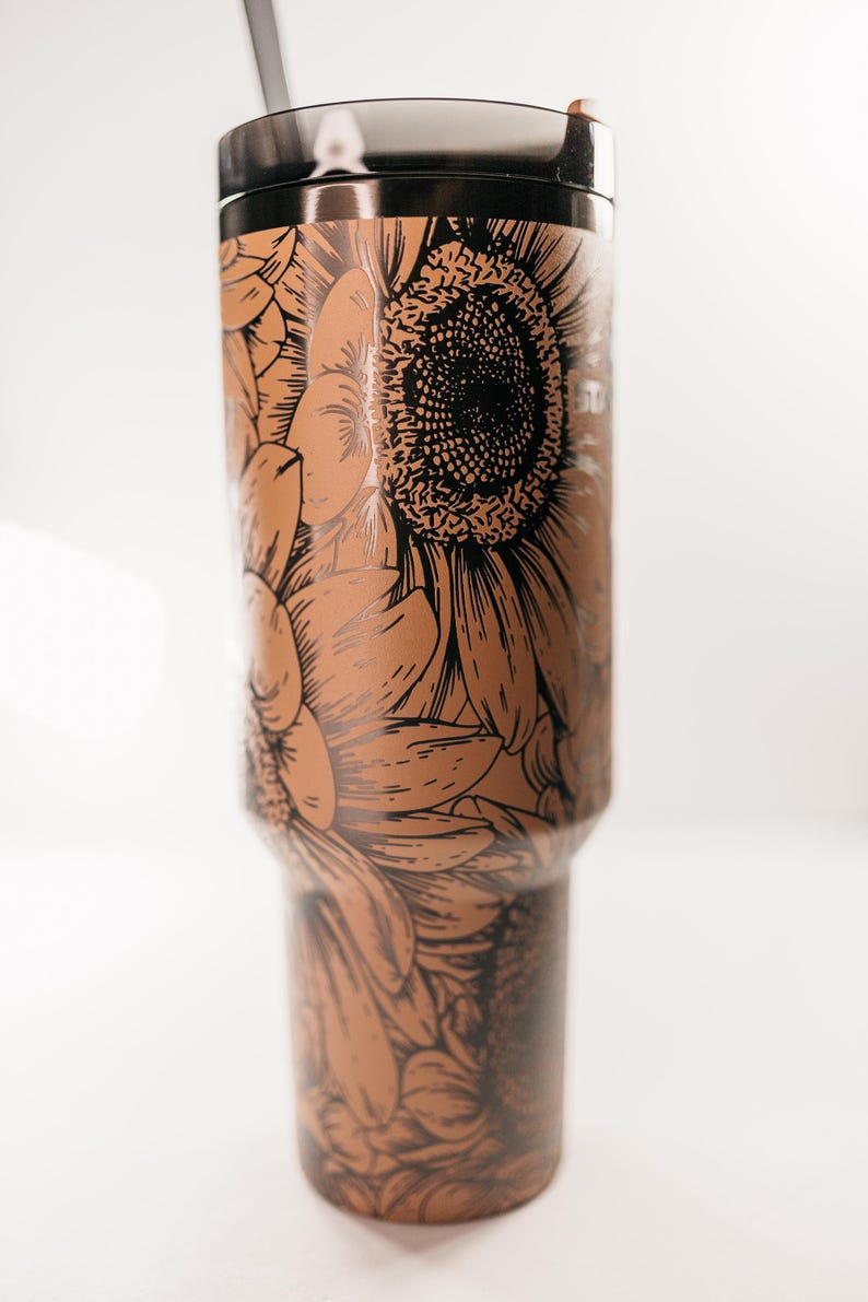 Pu&ograve; includere: Un bicchiere in acciaio inossidabile con coperchio e cannuccia neri. Il bicchiere &egrave; decorato con un dettagliato motivo a girasole marrone e nero. Il motivo floreale avvolge l'intero corpo del bicchiere.