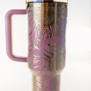Pu&ograve; includere: Un bicchiere in acciaio inossidabile con manico e coperchio rosa, con un design floreale dorato e rosa. La parola "Mama" &egrave; scritta sul lato. Include una cannuccia rosa.