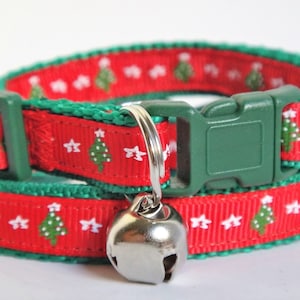 May include: Red and green cat collar with a Christmas tree pattern and a silver bell.