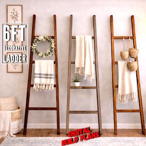 May include: Three decorative wooden ladders, each approximately 6 feet tall, are displayed against a neutral wall. One ladder holds a white towel with gray stripes, another has a white wreath, and the third has hanging baskets. The text "6FT DECORATIVE LADDER" is visible.