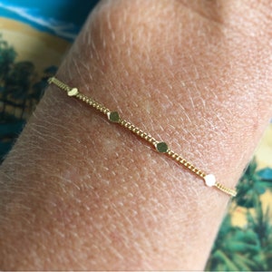 Puede incluir: Una delicada pulsera dorada con una fina cadena y peque&ntilde;os abalorios circulares espaciados. La pulsera es una joya sencilla y elegante, perfecta para el uso diario. La pulsera mide aproximadamente 17,8 cm de largo.