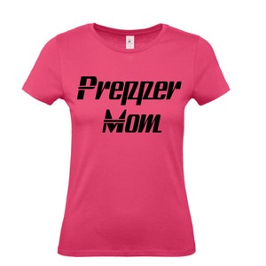 Könnte beinhalten: Ein pinkfarbenes T-Shirt mit dem Text "Prepper Mom" in Schwarz.