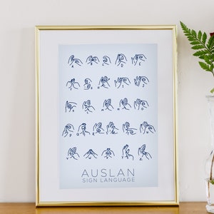 May include: A gold-framed print with a blue background showing the American Sign Language alphabet. The title "AUSLAN SIGN LANGUAGE" is printed at the bottom.