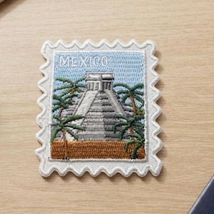 May include: A rectangular embroidered patch shaped like a postage stamp featuring a grey stepped pyramid structure surrounded by green palm trees against a light blue sky. The word MEXICO is stitched in white at the top of the design.