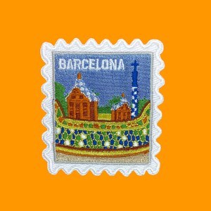 Pu&ograve; includere: Toppa ricamata bianca con un designo blu, verde e arancione di un edificio con la parola "BARCELONA" sopra.