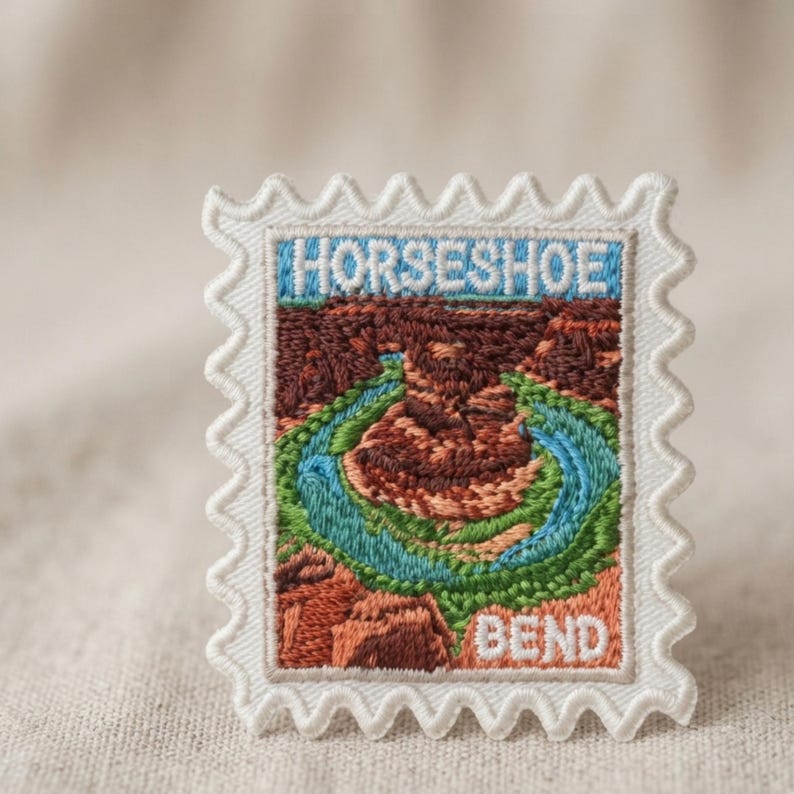 May include: A rectangular embroidered patch shaped like a postage stamp with a scalloped white border. The design features a landscape of Horseshoe Bend with a winding blue river, green banks, and brown rock formations. The text HORSESHOE is at the top and BEND is at the bottom in white.