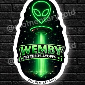 May include: A die-cut sticker featuring a glowing green alien head above a UFO emitting a bright green tractor beam over a city skyline. The text WEMBY TO THE PLAYOFFS is displayed in a bold green font. The design includes stars on a black background.
