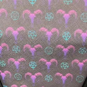 May include: Close-up of a fabric with a repeating pattern of pink and purple ram horns and teal pentagrams on a dark gray background. The design has a subtle, textured appearance, creating a unique visual effect. The overall theme is gothic and occult.
