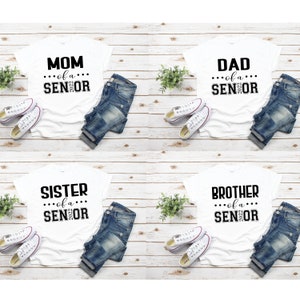 May include: Four white t-shirts with black text. The shirts say "Mom of a Senior 2023", "Dad of a Senior 2023", "Sister of a Senior 2023", and "Brother of a Senior 2023".