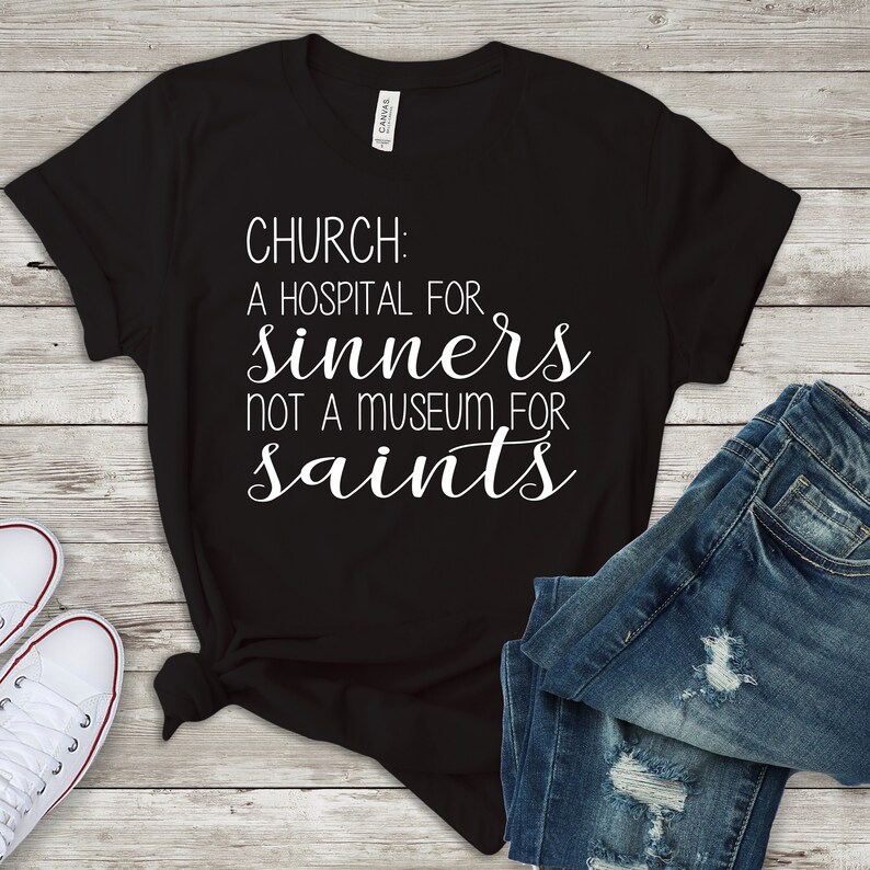 May include: Black t-shirt with white text that reads "Church: A hospital for sinners not a museum for saints."