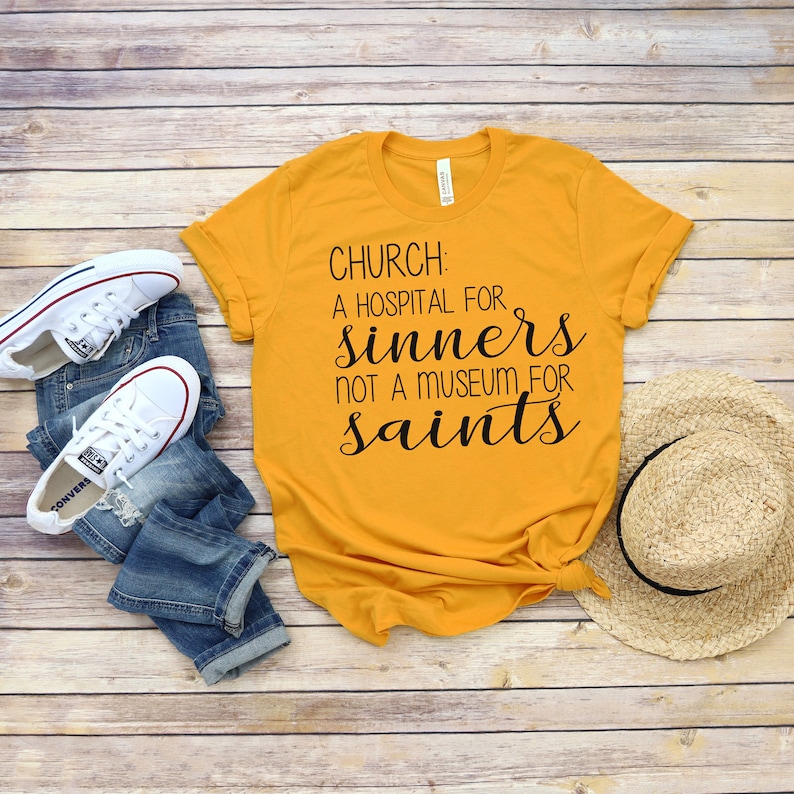 May include: A yellow t-shirt with the text "CHURCH: A HOSPITAL FOR SINNERS NOT A MUSEUM FOR SAINTS" printed in black.