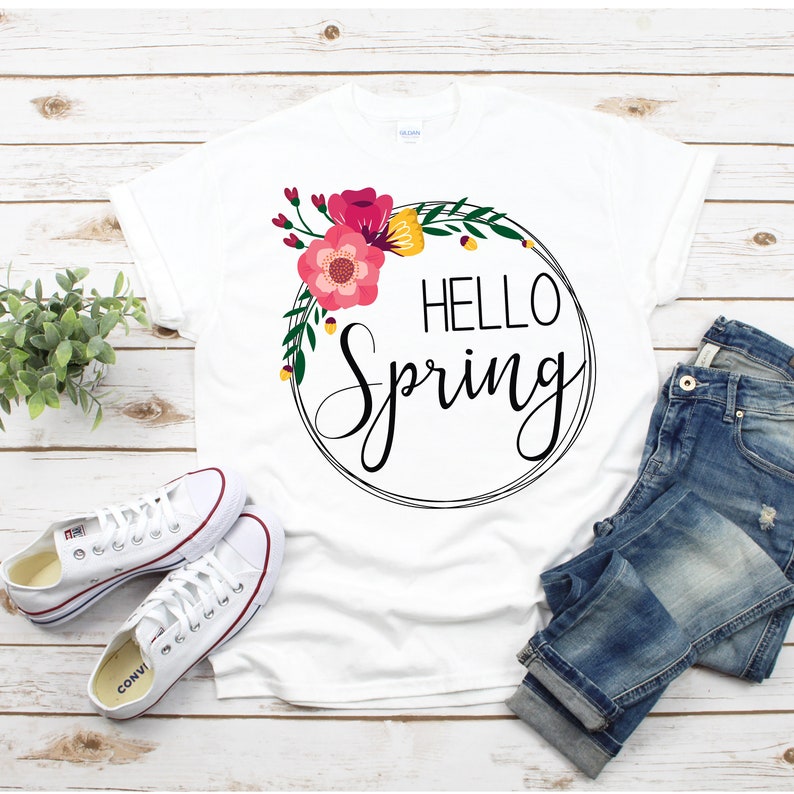 May include: White t-shirt with a floral wreath and the text "HELLO Spring" in black script.