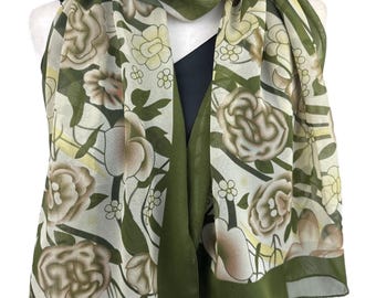 Pode incluir: Um lenço estampado floral verde e branco com um design floral castanho. O lenço é feito de um tecido leve e tem uma borda franjada.