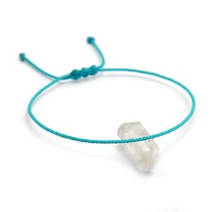Peut inclure: Un bracelet en cordon turquoise avec un pendentif en cristal de quartz transparent.