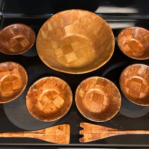Pu&ograve; includere: Un set di sette insalatiere in legno e un cucchiaio per insalata in legno. Le insalatiere sono tutte in legno intrecciato e hanno un colore marrone naturale. Il cucchiaio &egrave; anch'esso in legno intrecciato e ha un colore marrone naturale.