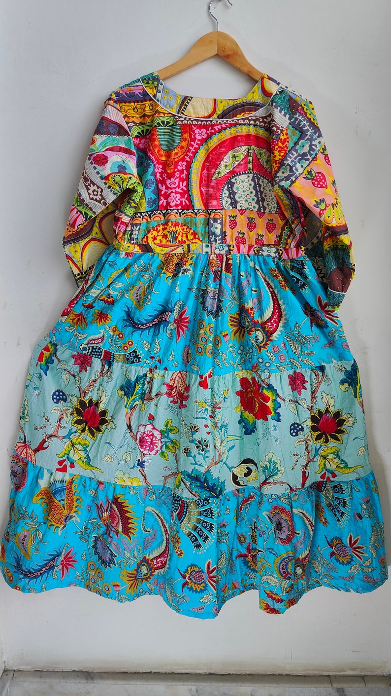 Peut inclure: Une longue robe &agrave; volants avec un corsage en patchwork pr&eacute;sentant une vari&eacute;t&eacute; de motifs floraux et g&eacute;om&eacute;triques color&eacute;s. La jupe est d'un bleu &eacute;clatant avec un imprim&eacute; floral.