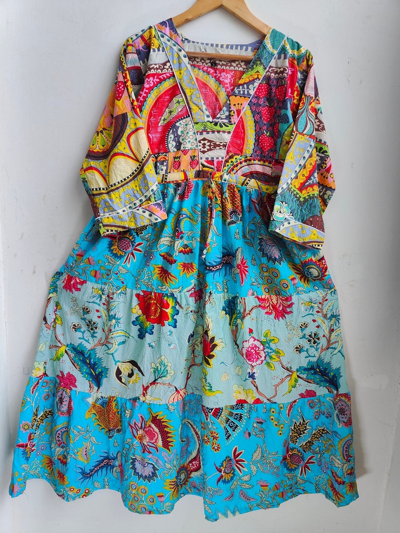 Peut inclure: Une robe maxi color&eacute;e &agrave; plusieurs couches avec un d&eacute;collet&eacute; en V et un imprim&eacute; floral. La robe est en coton et a une coupe ample.