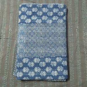May include: A blue and white kantha quilt with a geometric pattern. The quilt is made of cotton and is hand-stitched.