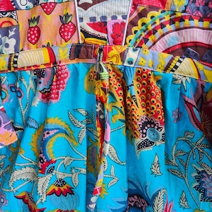 Peut inclure: Une robe &agrave; motifs bleus et blancs avec un motif floral color&eacute;. La robe a un col en V et une fermeture &agrave; nouer dans le dos.