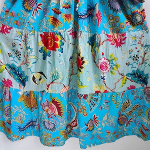 Peut inclure: Une robe &agrave; imprim&eacute; floral bleu et blanc avec une jupe &agrave; volants. La robe est de style patchwork avec diff&eacute;rents motifs floraux.